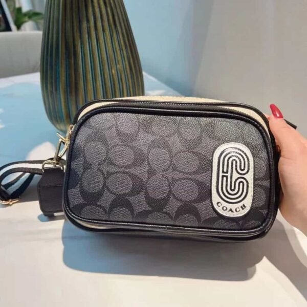 Cartera COACH crossbody negra con logo C moderno.