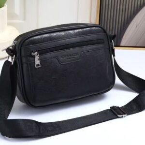 Bandolera COACH negra unisex con logo grabado y correa ajustable.