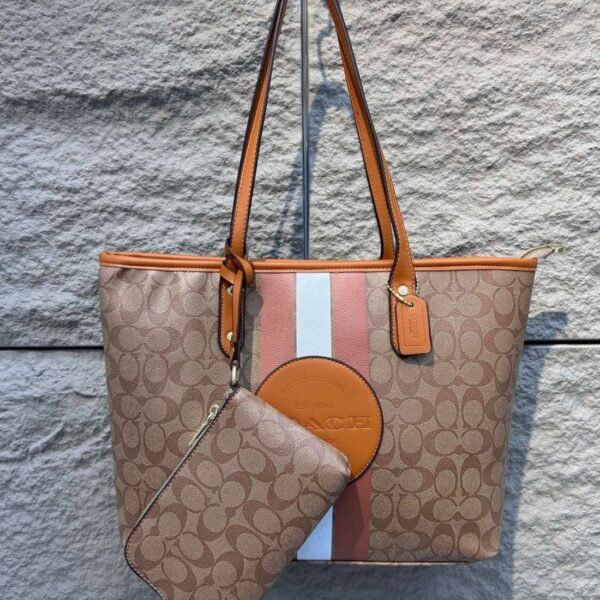 Cartera COACH tote color marrón con franjas centrales y estuche adicional.