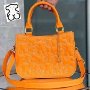 Cartera tipo TOUS color con diseño acolchado de ositos en relieve.